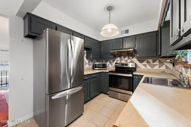 a kitchen with stainless steel appliances granite countertop a refrigerator and a sink