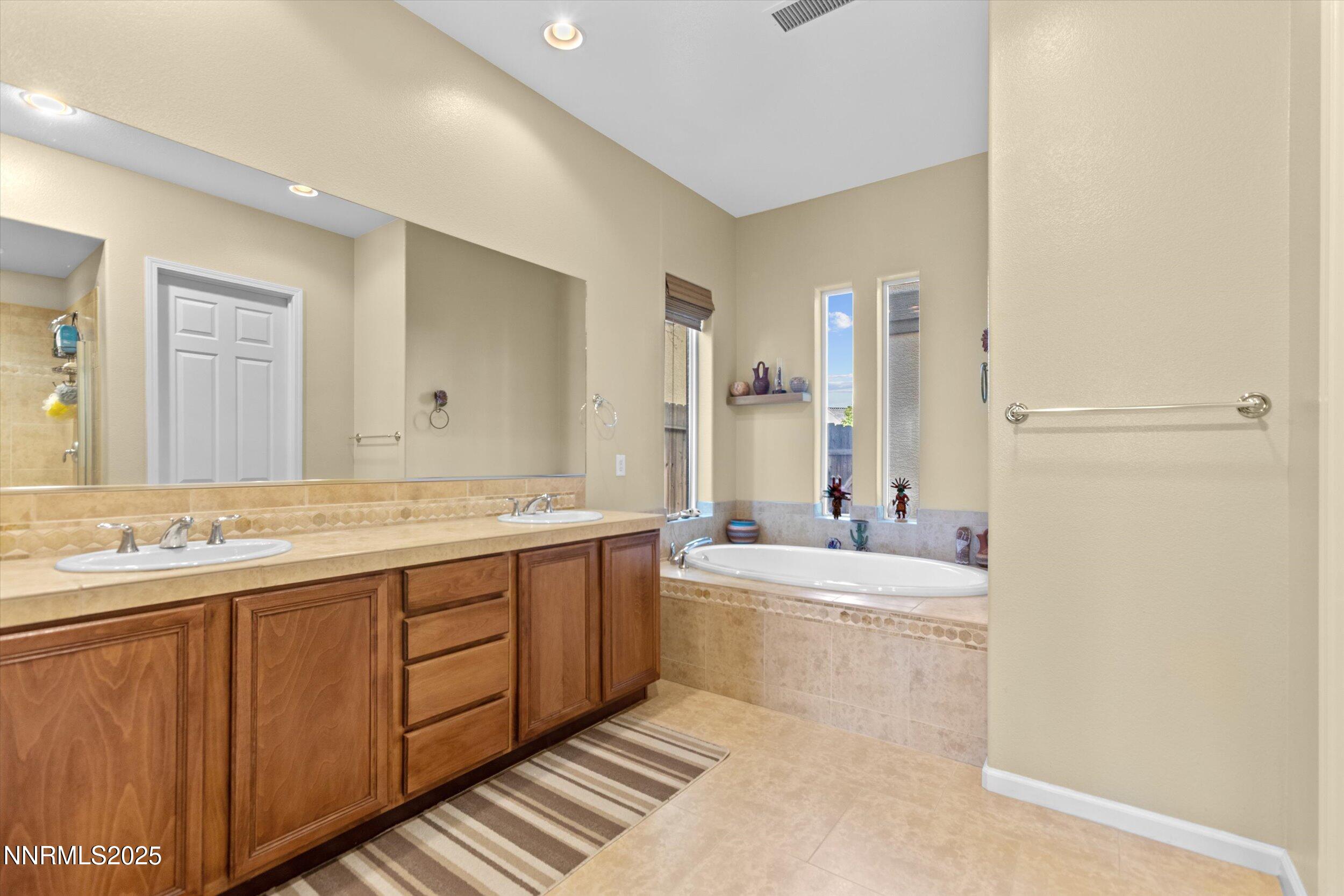 10900 Serratina Drive Reno, NV 89521 - Photo 21 of 47 a large bathroom with a double vanity sink mirror and bathtub