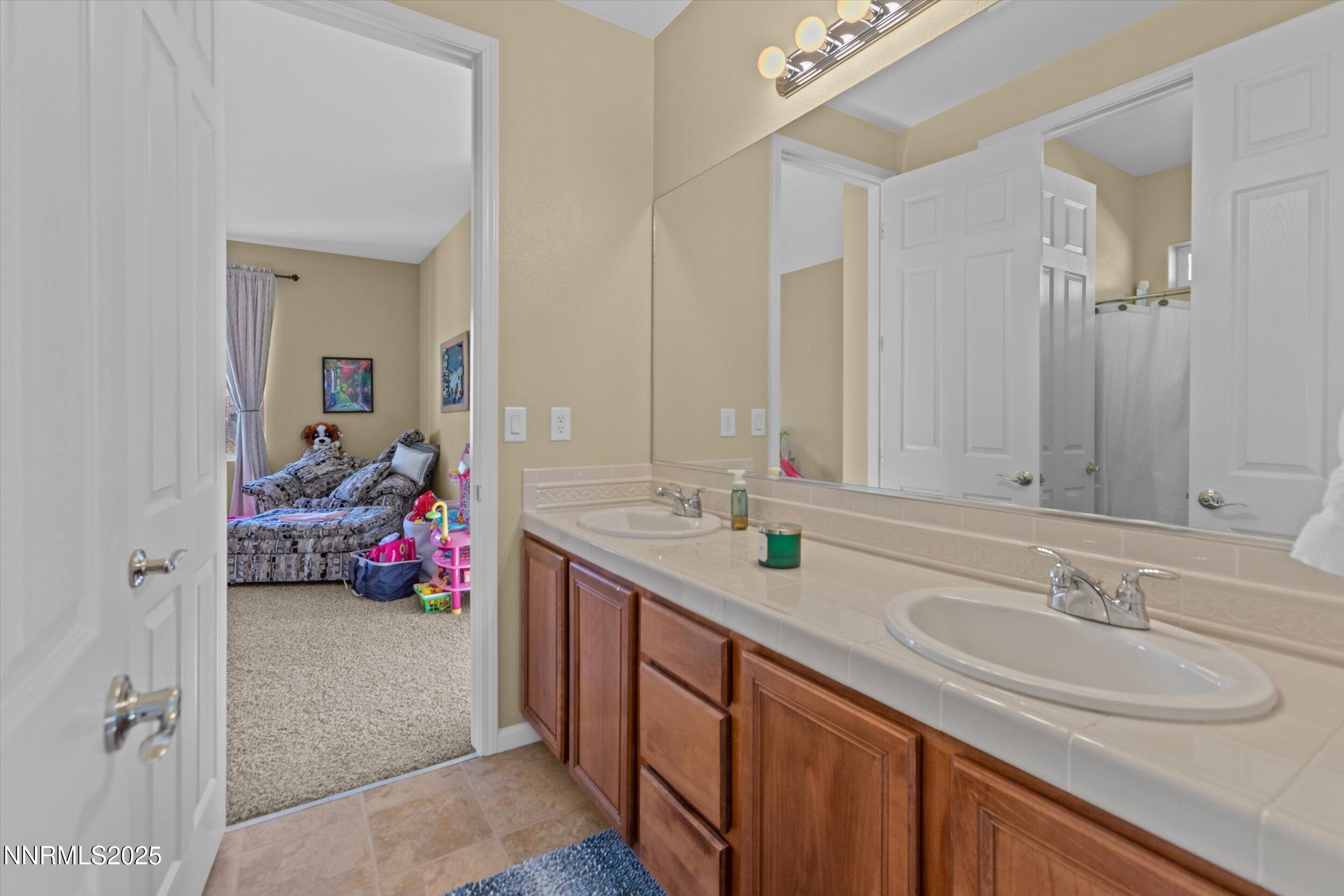 10900 Serratina Drive Reno, NV 89521 - Photo 24 of 47 a bathroom with a sink double vanity and a mirror