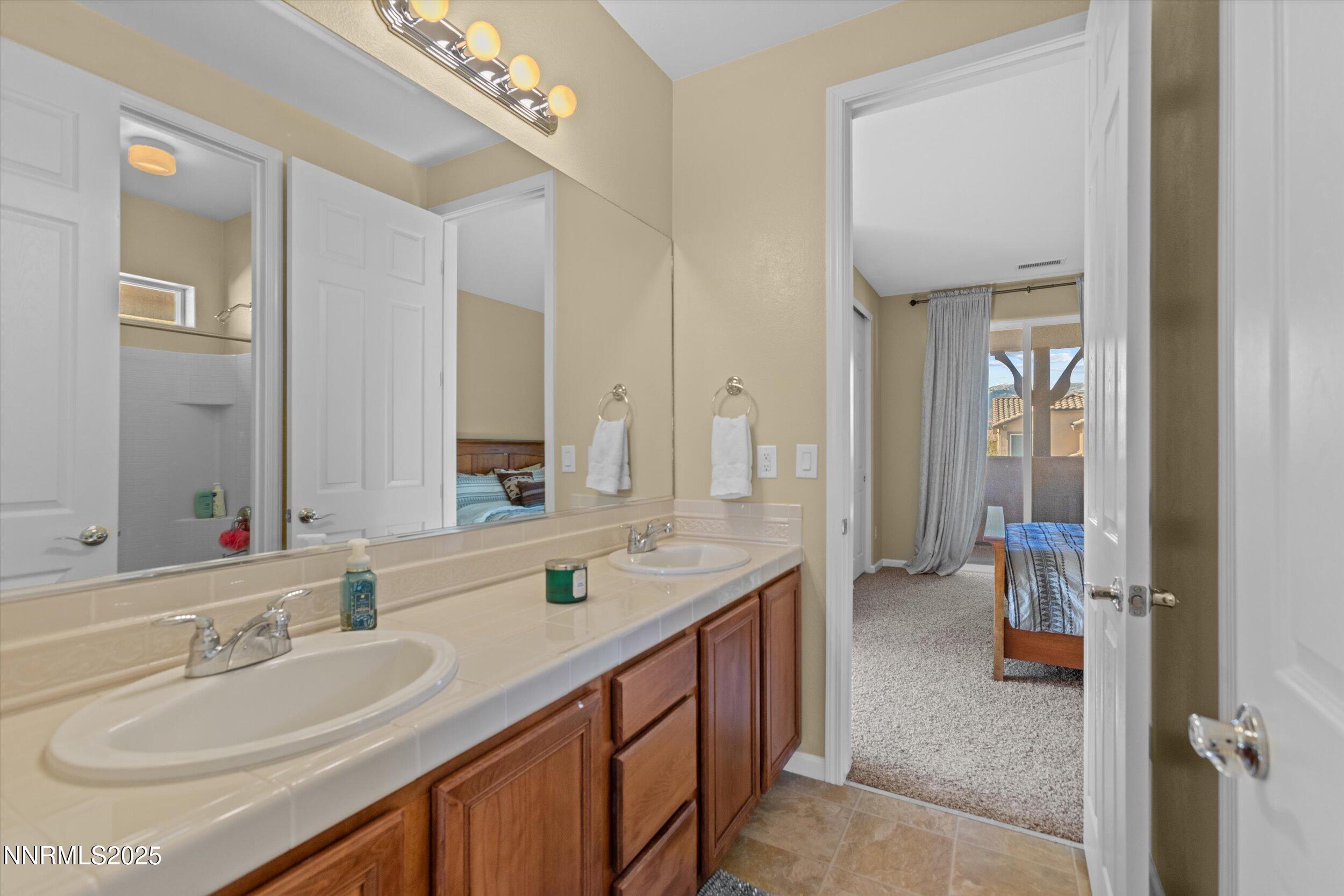 10900 Serratina Drive Reno, NV 89521 - Photo 26 of 47 a en suite bathroom with a sink double vanity and a mirror