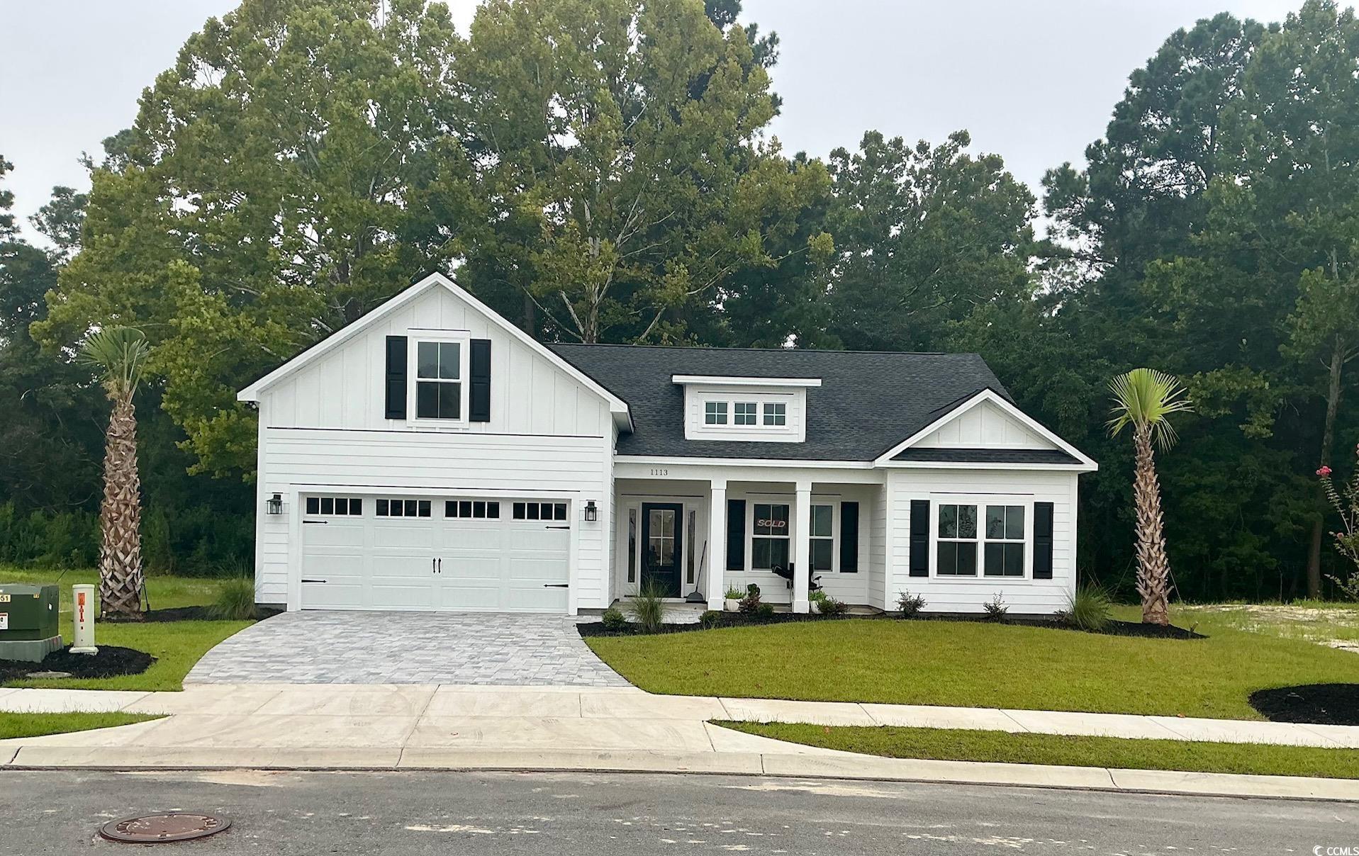 Modern farmhouse with a porch, a front lawn, decor