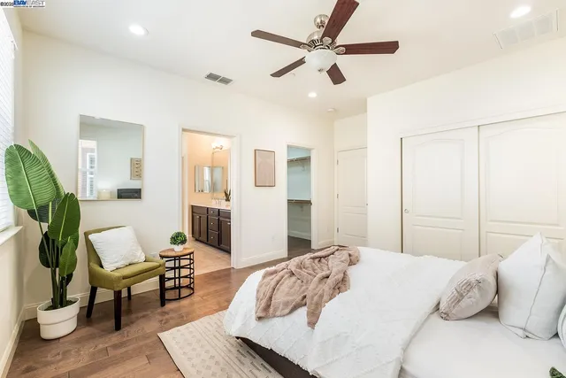 a bedroom with a bed a couch and a chandelier