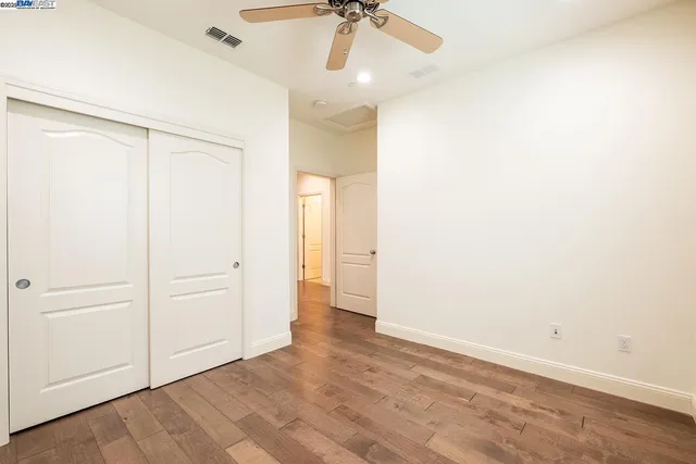 an empty room with a ceiling fan and carpet