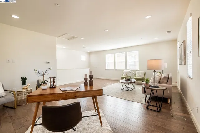 a living room with furniture a table and wooden floor