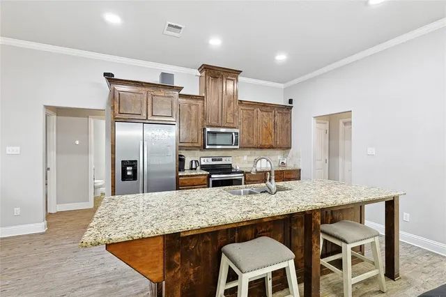 a kitchen with granite countertop kitchen island cabinets stainless steel appliances and a counter space