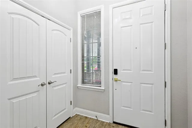 an entryway with wooden floor and cabinet