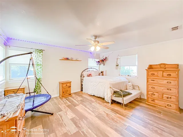 a spacious bedroom with a bed a rug and dresser