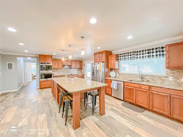 a kitchen with stainless steel appliances granite countertop a sink and a refrigerator