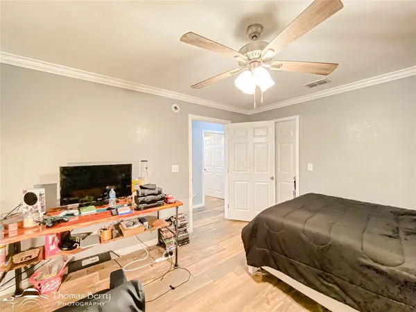 a bedroom with a bed and a flat tv screen on a dresser