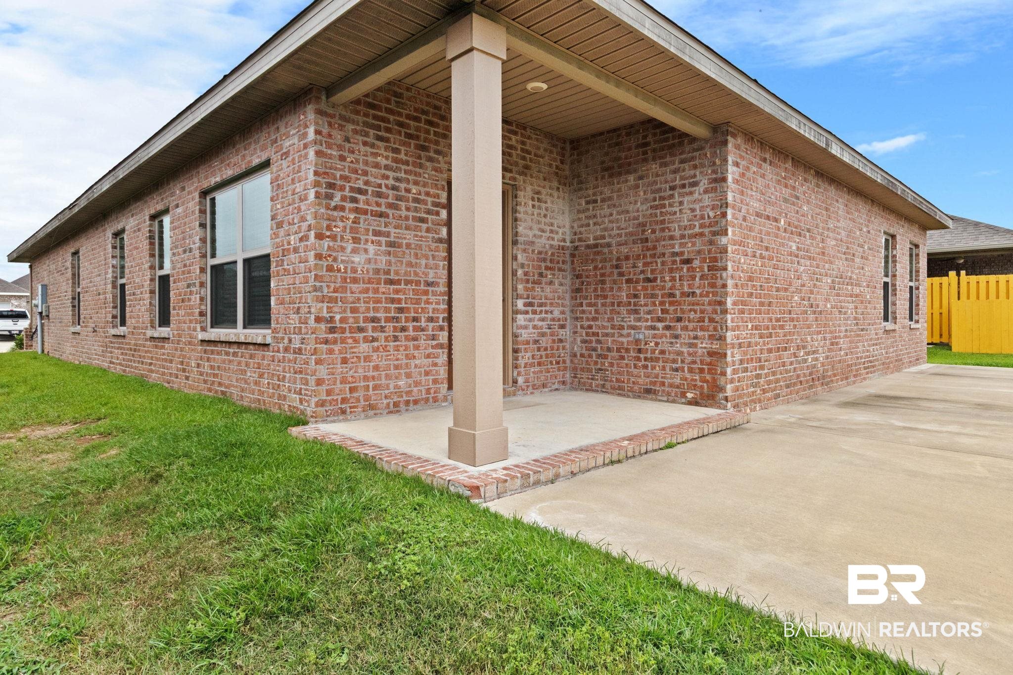 1710 Grouse Street Foley, AL 36535 - Photo 71 of 76 Brick exterior featuring multiple windows, a concrete driveway, and a covered entry with a support column