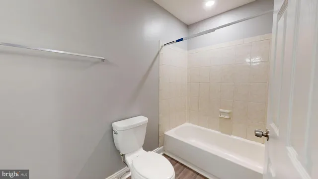 a white toilet sitting next to a bath tub