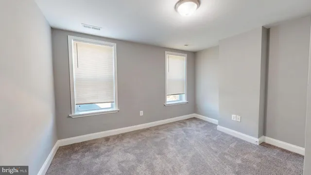 an empty room with windows and closet