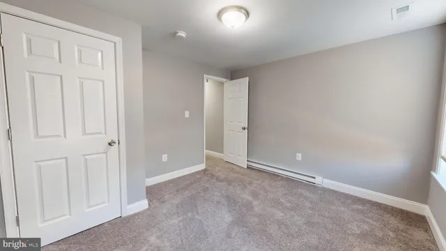 an empty room with windows & closet area