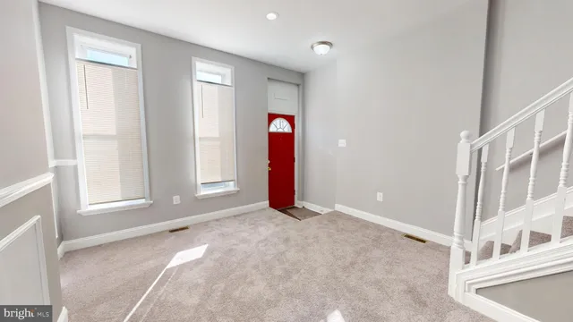 a view of an empty room with wooden floor and entryway