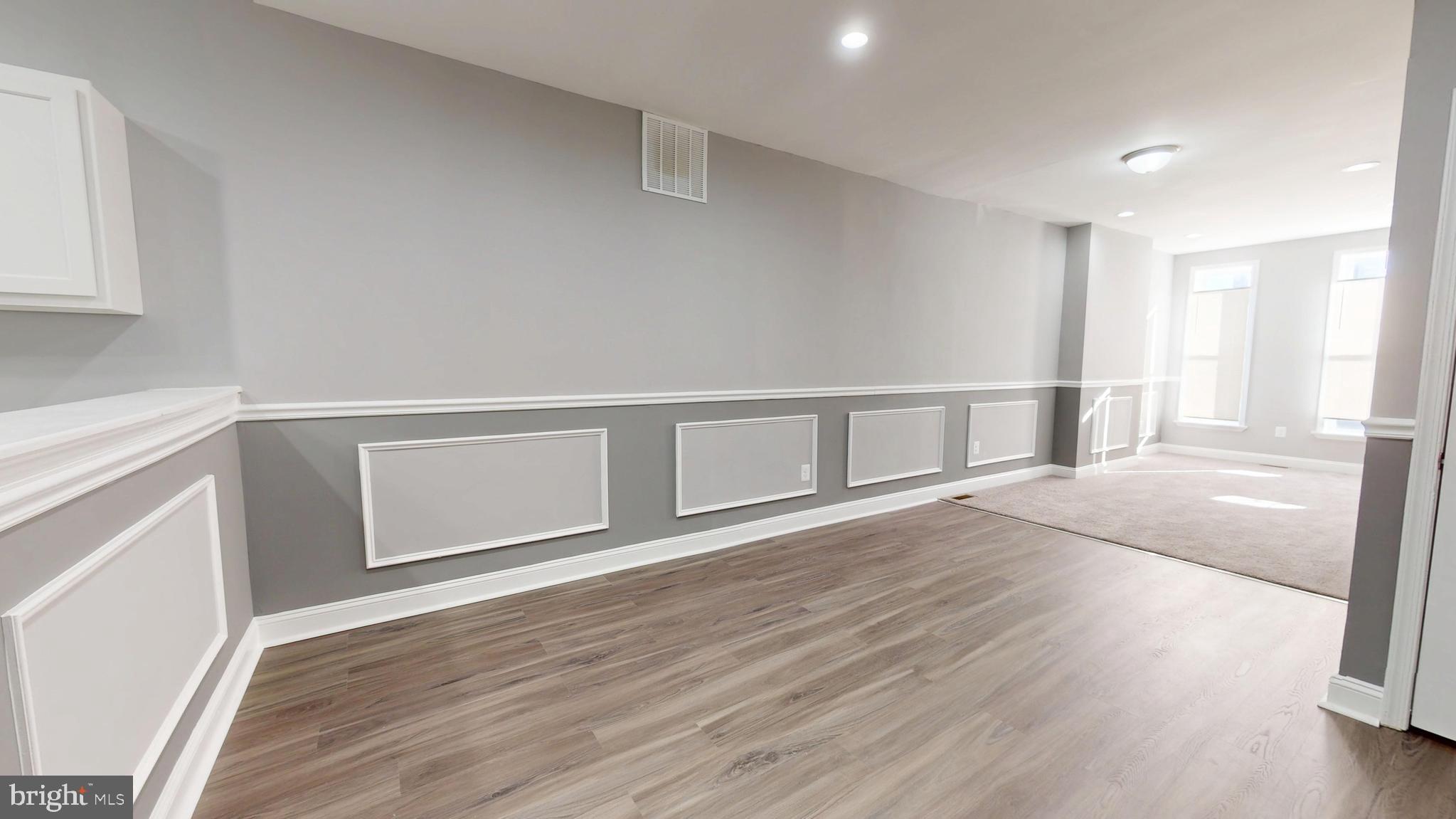 1824 Federal Street Baltimore, MD 21213 - Photo 4 of 17 a view of an empty room with wooden floor and a window