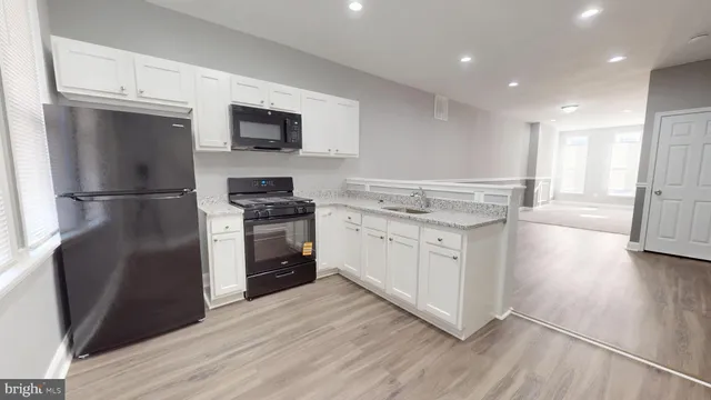 a kitchen with a refrigerator stove and white cabinets