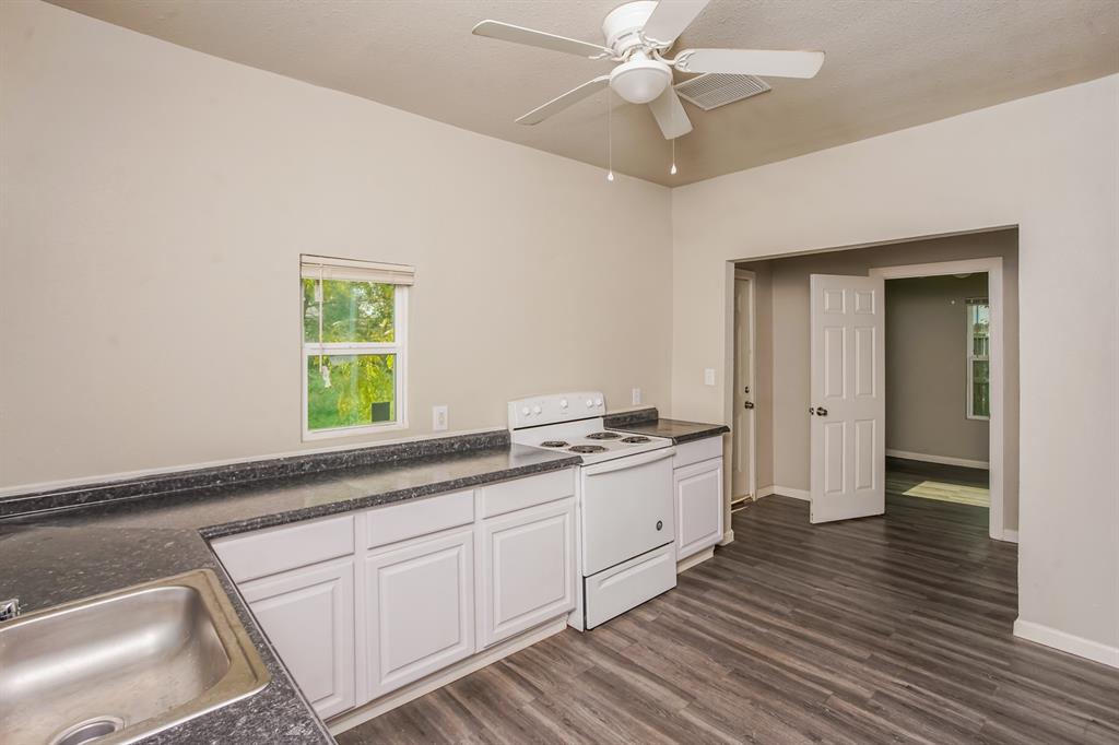 2402 Summer Avenue Waco, TX 76708 - Photo 6 of 15 Kitchen featuring white cabinetry, dark speckled countertops, and a stainless steel sink