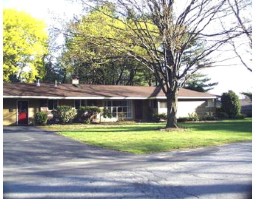 a front view of a house with a yard and trees
