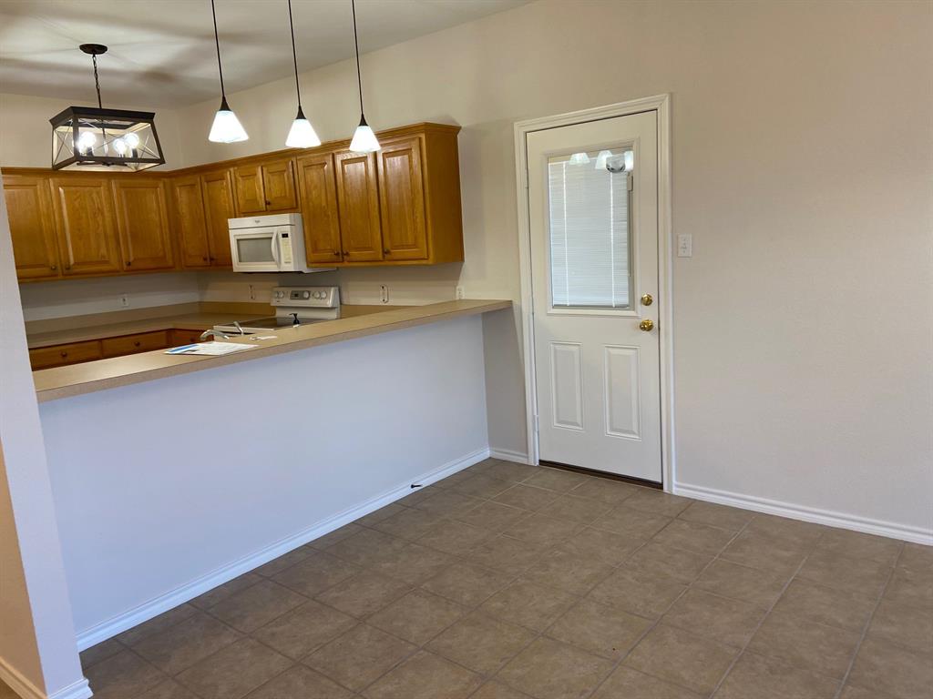 27101 Meadowmore Court Whitney, TX 76692 - Photo 9 of 32 Kitchen bar area blending into dining area.