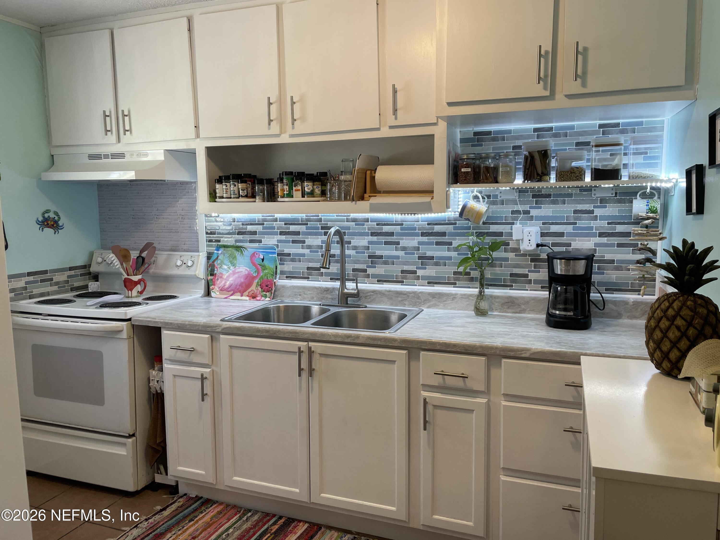 709 North 11th Street Palatka, FL 32177 - Photo 3 of 33 a kitchen with stainless steel appliances granite countertop a sink stove and cabinets
