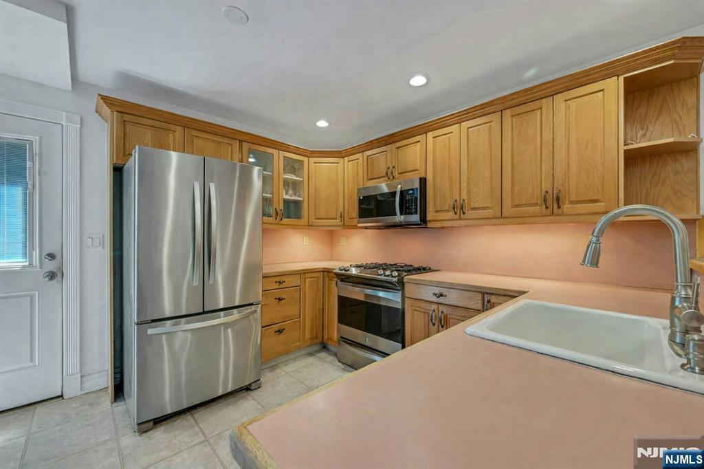 44 West Midland Avenue Paramus, NJ 07652 - Photo 10 of 19 a kitchen with stainless steel appliances granite countertop a refrigerator stove microwave and sink