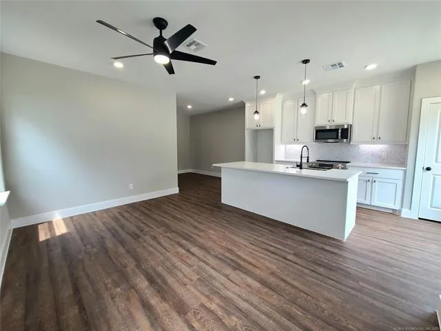 a view of kitchen with granite countertop a sink counter top space and stainless steel appliances