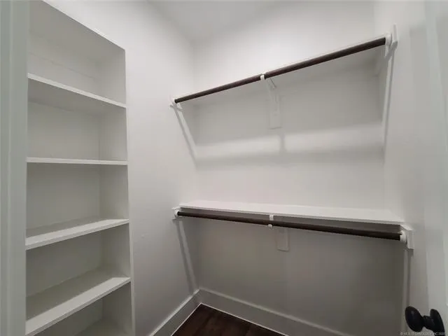 a view of walk in closet with empty racks