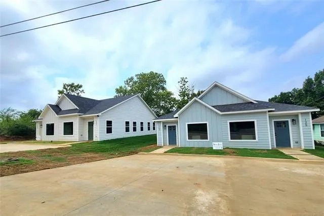 a front view of a house with a garden and yard