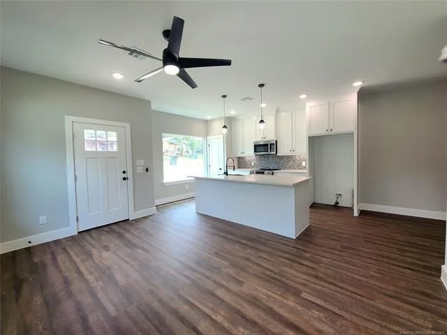 a kitchen with stainless steel appliances granite countertop a dishwasher a stove and a refrigerator