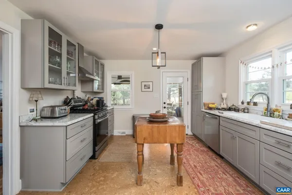 a kitchen that has a stove a table and chairs in it