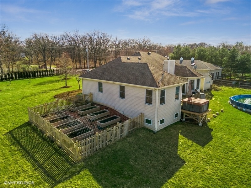 41-w580 McDonald Road Elgin, IL 60124 - Photo 19 of 25 a aerial view of a white house sitting in middle of the green field