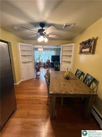a view of a dining room with furniture a chandelier and wooden floor