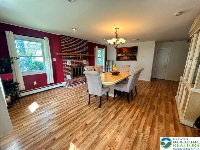 a dining room with furniture a fireplace and wooden floor