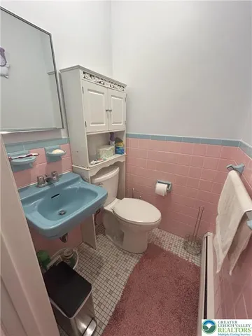a bathroom with a toilet a sink and a mirror