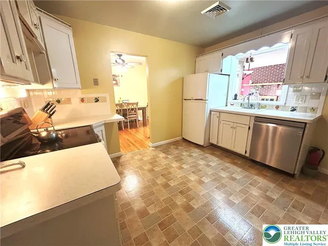 a large kitchen with stainless steel appliances a stove a sink dishwasher and cabinets