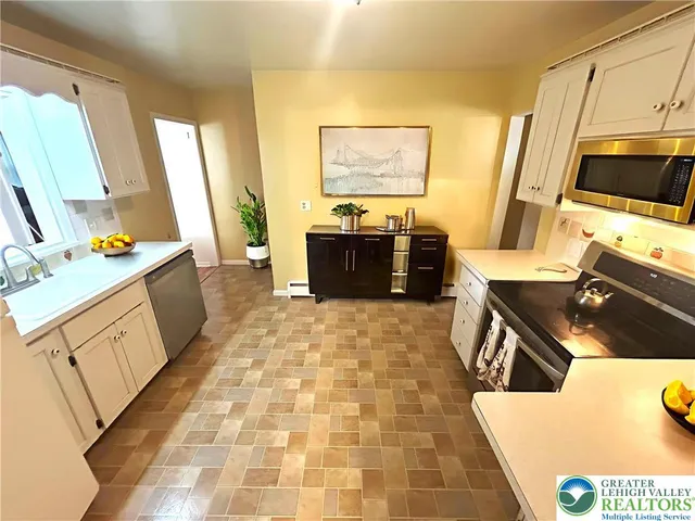 a kitchen with stainless steel appliances a stove a sink and a refrigerator