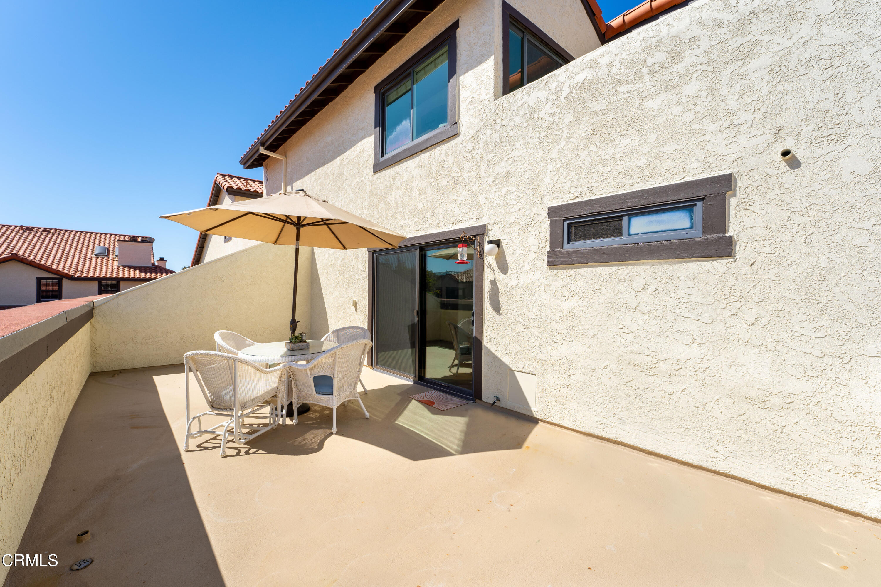 2263 Martinique Lane Oxnard, CA 93035 - Photo 14 of 38 a view of a patio with a dining table and chairs under an umbrella