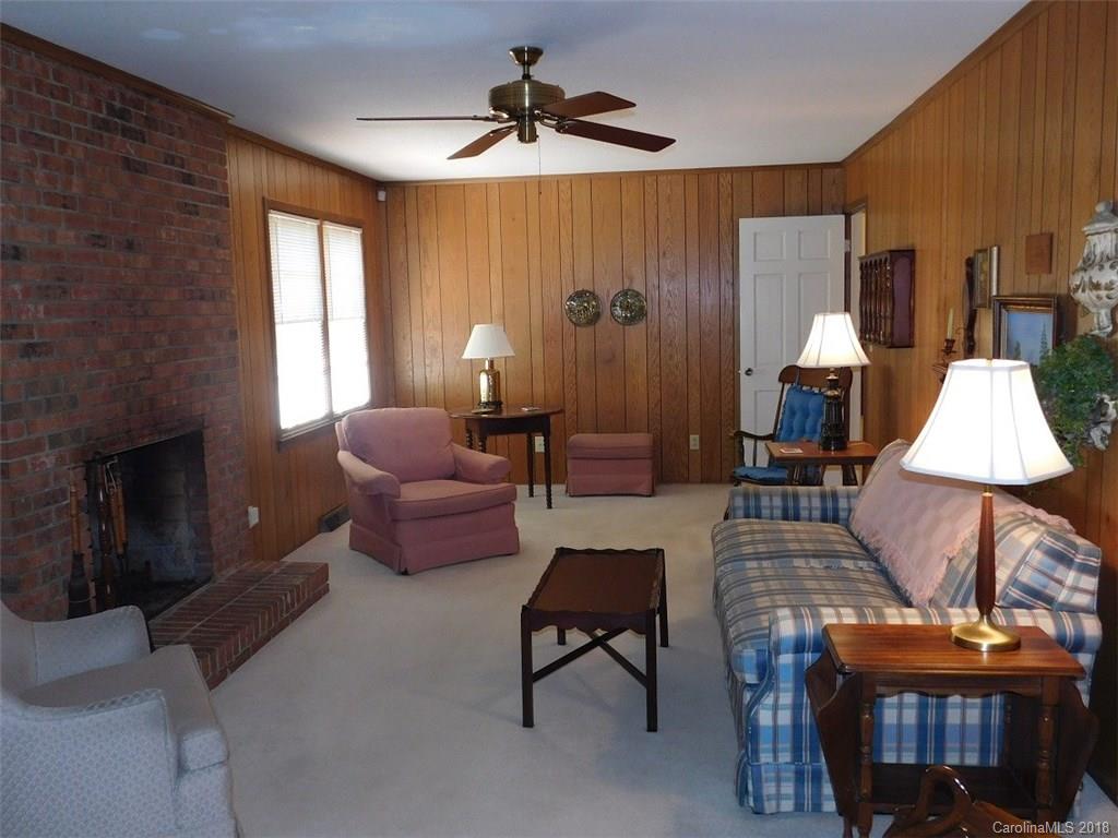 6311 Lake Forest Road East Charlotte, NC 28227 - Photo 14 of 31 a living room with furniture a lamp and a fireplace