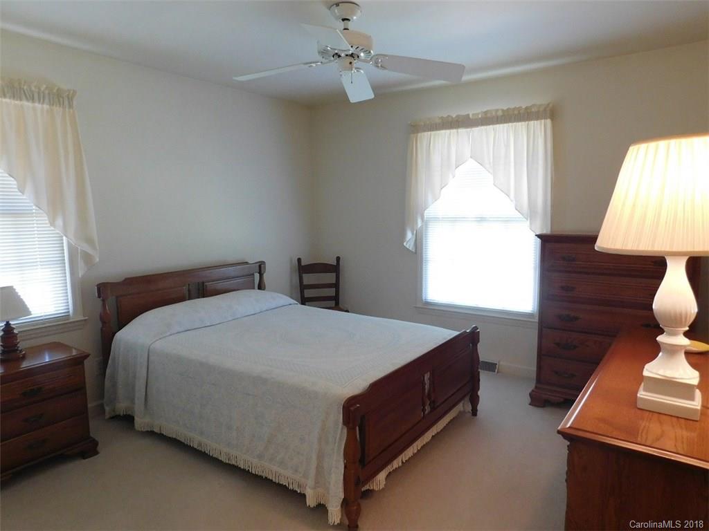 6311 Lake Forest Road East Charlotte, NC 28227 - Photo 21 of 31 a bed sitting in a bedroom next to a window