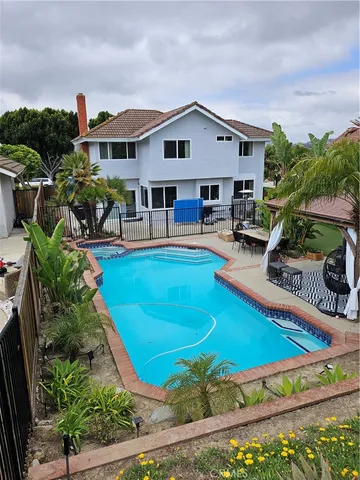 a view of a house with pool and chairs