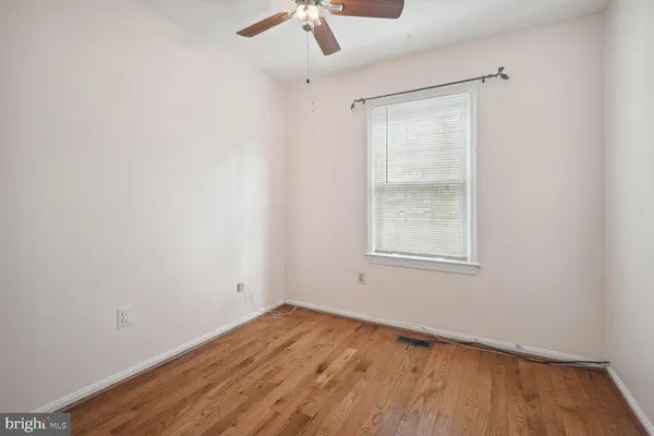 an empty room with a window and wooden floor