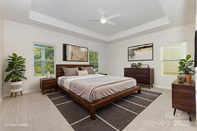 a bedroom with a large bed a potted plant and a window