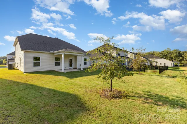 a view of a house with pool and a yard