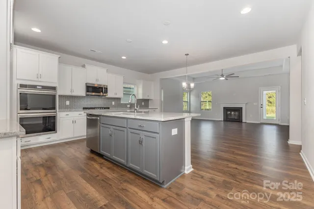 a kitchen with granite countertop a stove top oven and cabinets