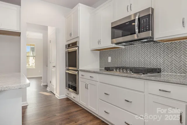 a kitchen with stainless steel appliances granite countertop a stove microwave and refrigerator