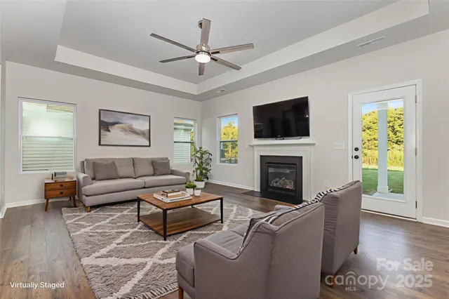 a living room with furniture a fireplace a flat screen tv and a window