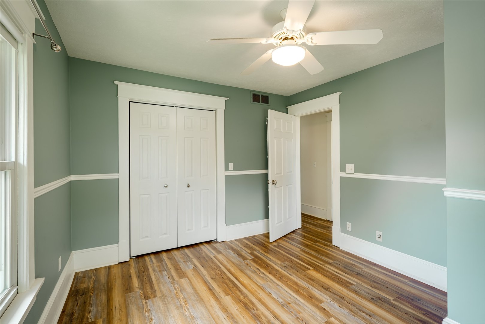 301 West Cooper Street Colfax, IL 61728 - Photo 32 of 69 a view of a room with wooden floor and a ceiling fan
