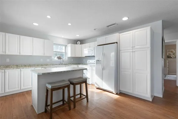 a kitchen with granite countertop a sink stove and refrigerator