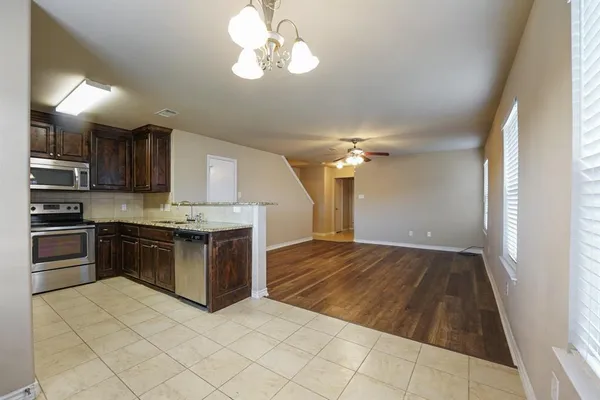 a kitchen with kitchen island granite countertop a sink cabinets and stainless steel appliances