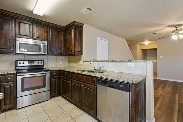a kitchen with stainless steel appliances granite countertop a sink stove and microwave